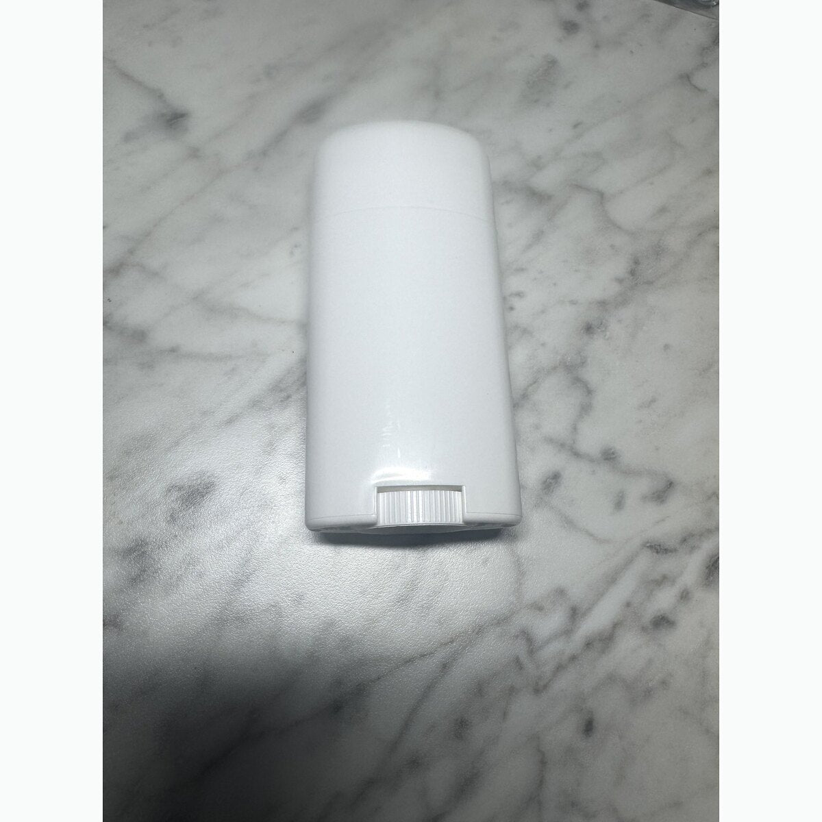 Unlabeled white Bare Armor deodorant container shown on a marble surface